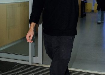 Chris Martin reže nisku ključnu figuru u trapericama i bejzbol kapu dok uživa u putovanju u kazalište u Londonu