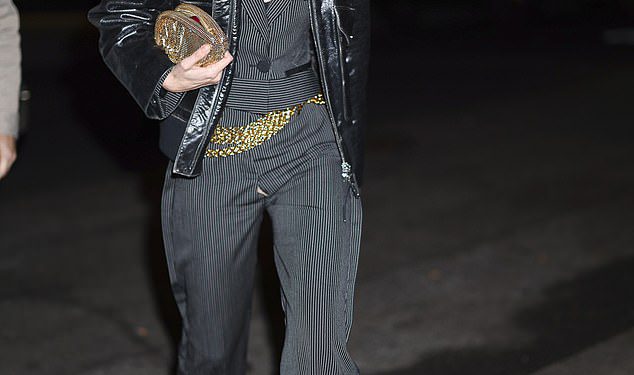 Gigi Hadid reže oštri lik u kombinezonu sive Pinstripe i crnu kožnu jaknu dok izlazi nakon završetka pucanja kampanje Rabanne Million Gold u New Yorku