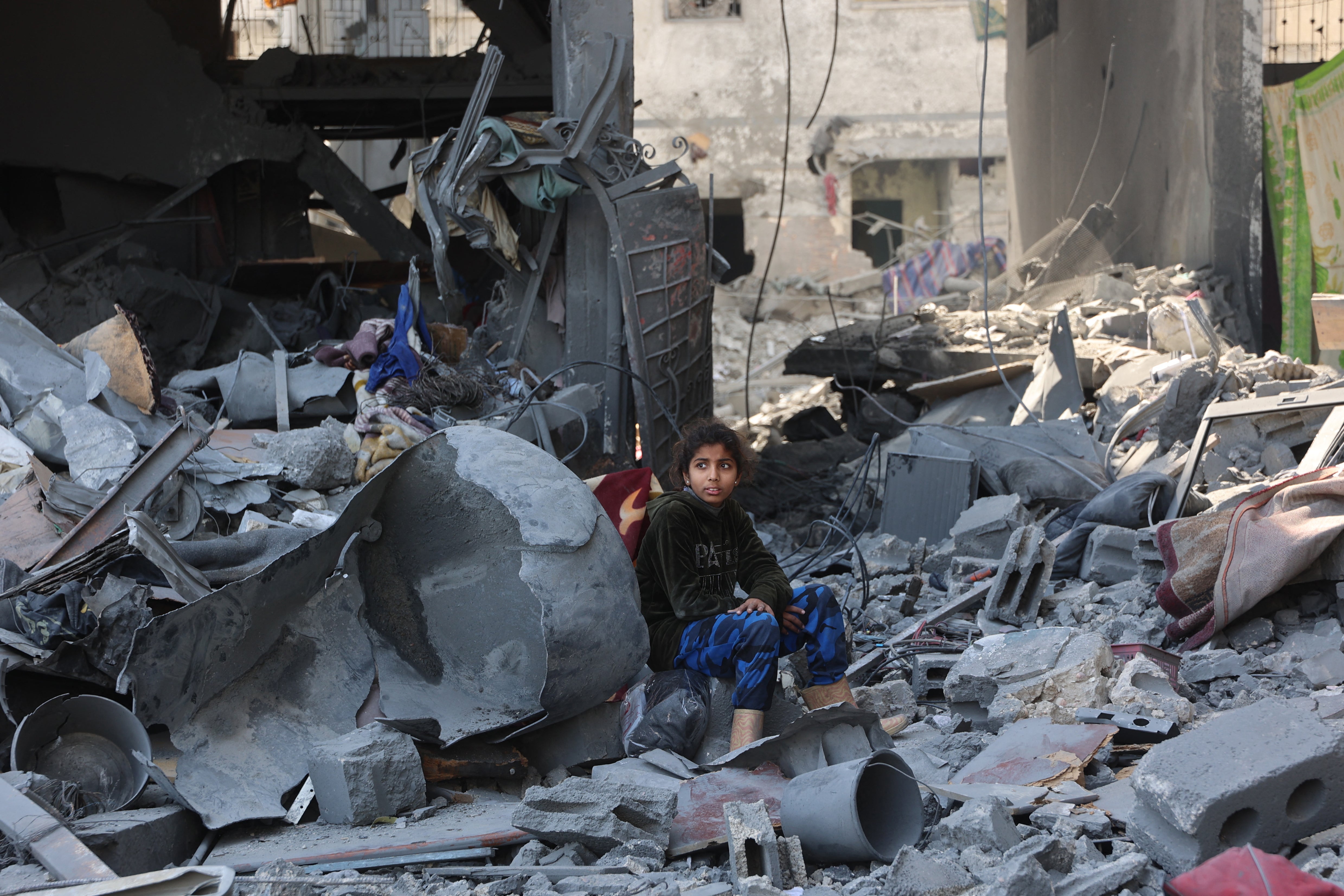 Palestinska djevojka sjedi među ruševinama obiteljske kuće Qrayqea