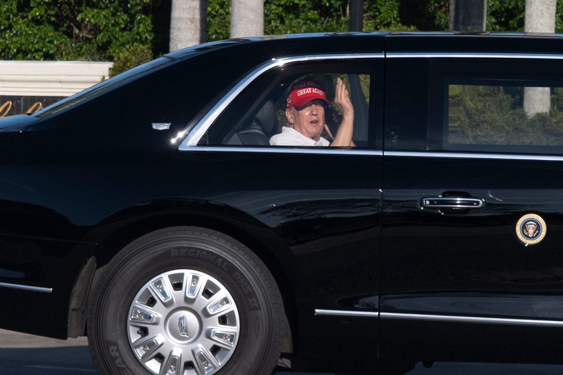Predsjednik Donald Trump mahne iz njegove limuzine dok stiže u svoj golf klub u West Palm Beachu 8. ožujka 2025