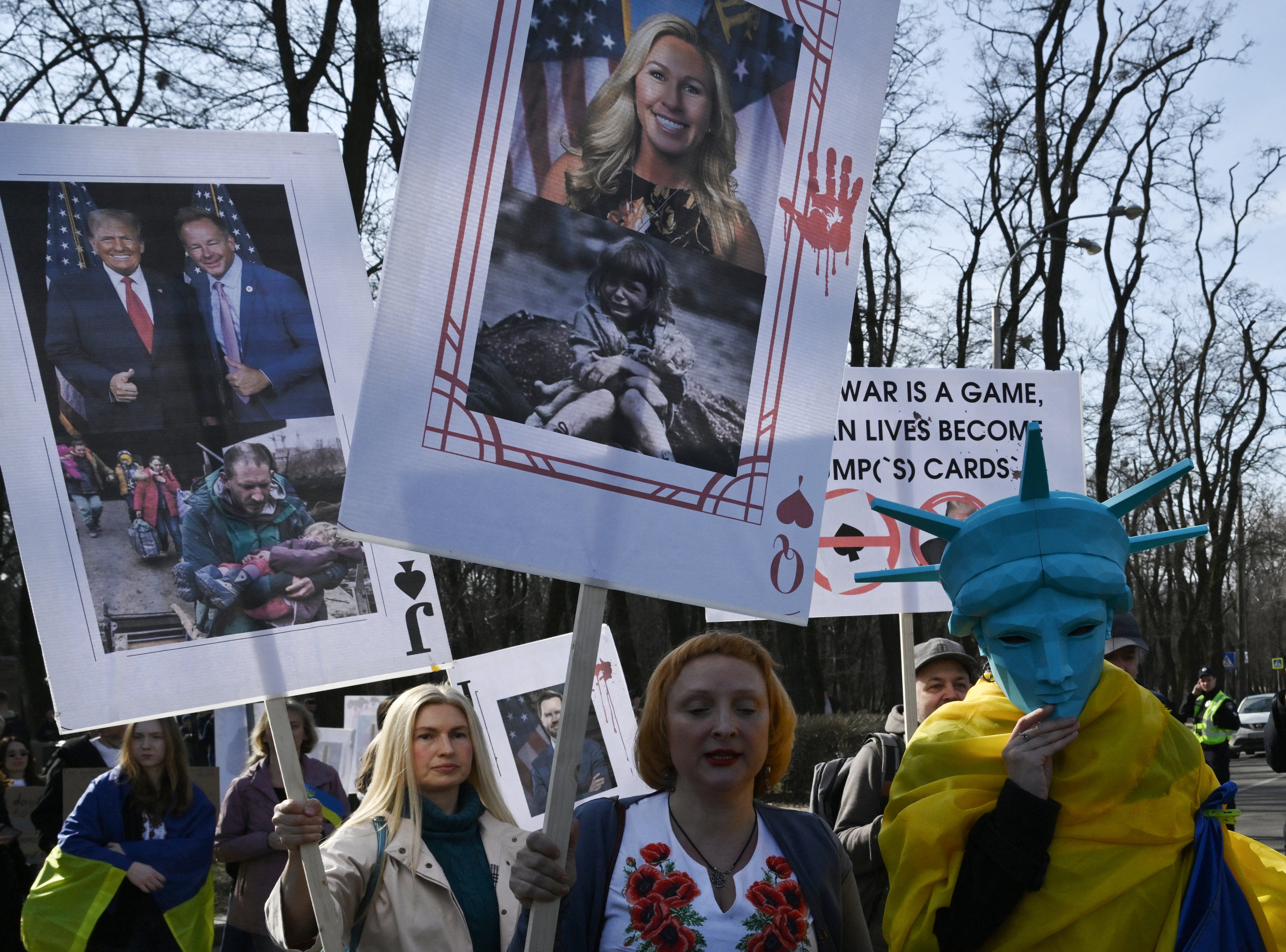 Demonstrator (C) drži plakat koji prikazuje američku kongresnu ženicu Marjorie Taylor Greene tijekom prosvjeda zvanog