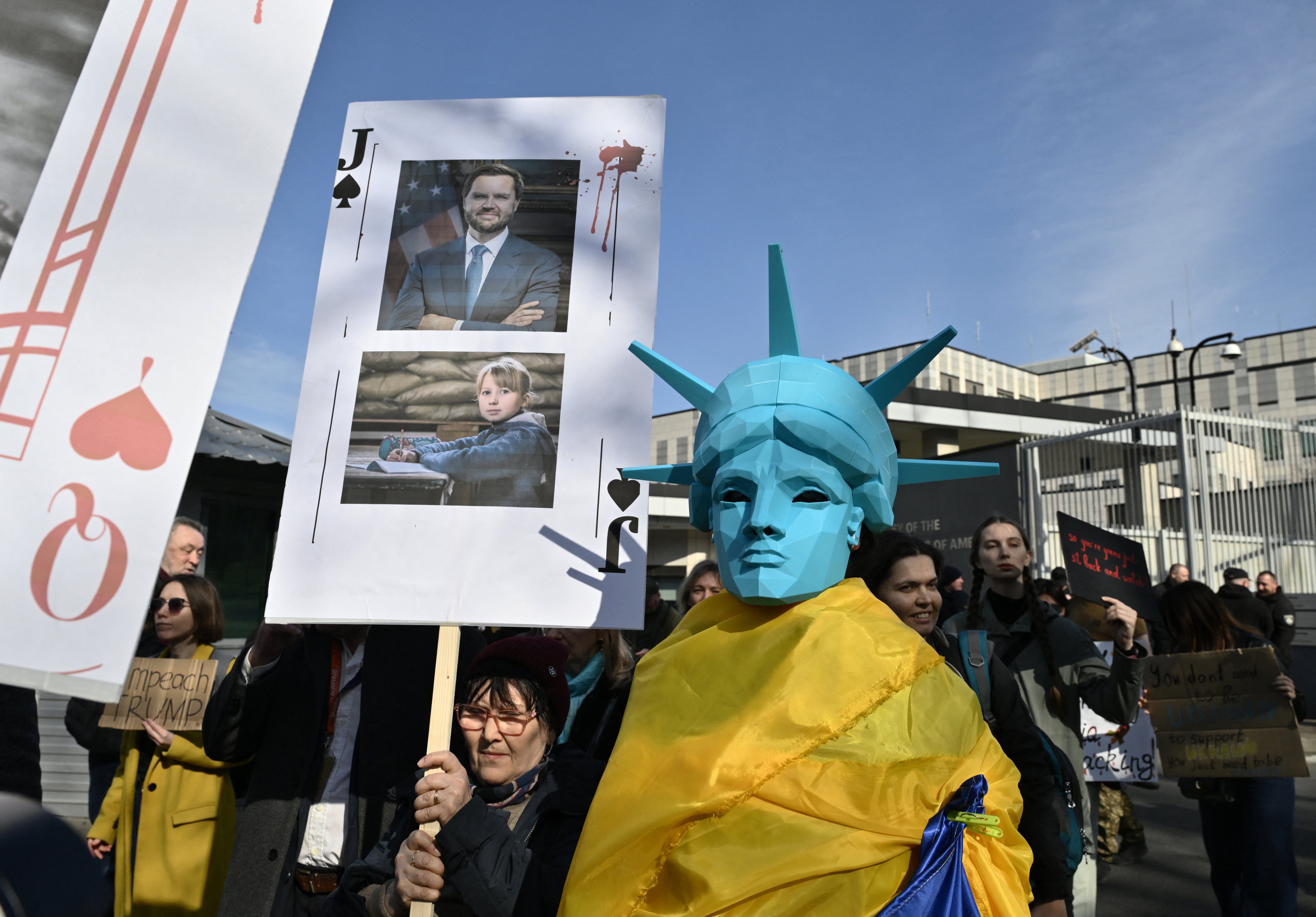 Demonstrator ima plakatu s prikazom američkog potpredsjednika JD Vancea. Mala skupina Ukrajinaca okupila se izvan veleposlanstva dok je zemlja ljuljala preko noći udaraca u kojima je poginulo najmanje 14 ljudi i ranila desetine više.