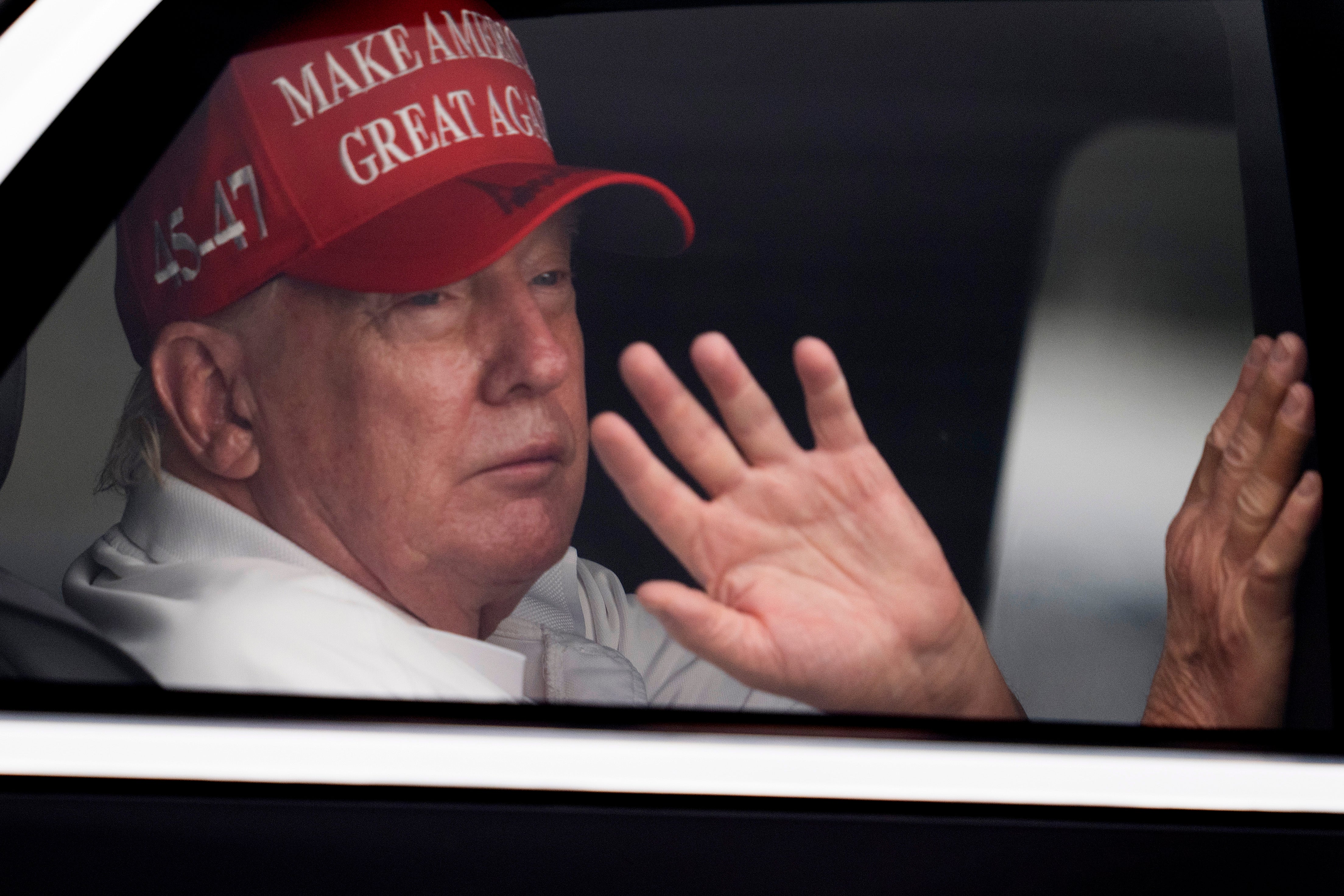 Predsjednik Donald Trump mahne pristalicama iz njegove limuzine dok stiže u Trump International Golf Club u West Palm Beachu