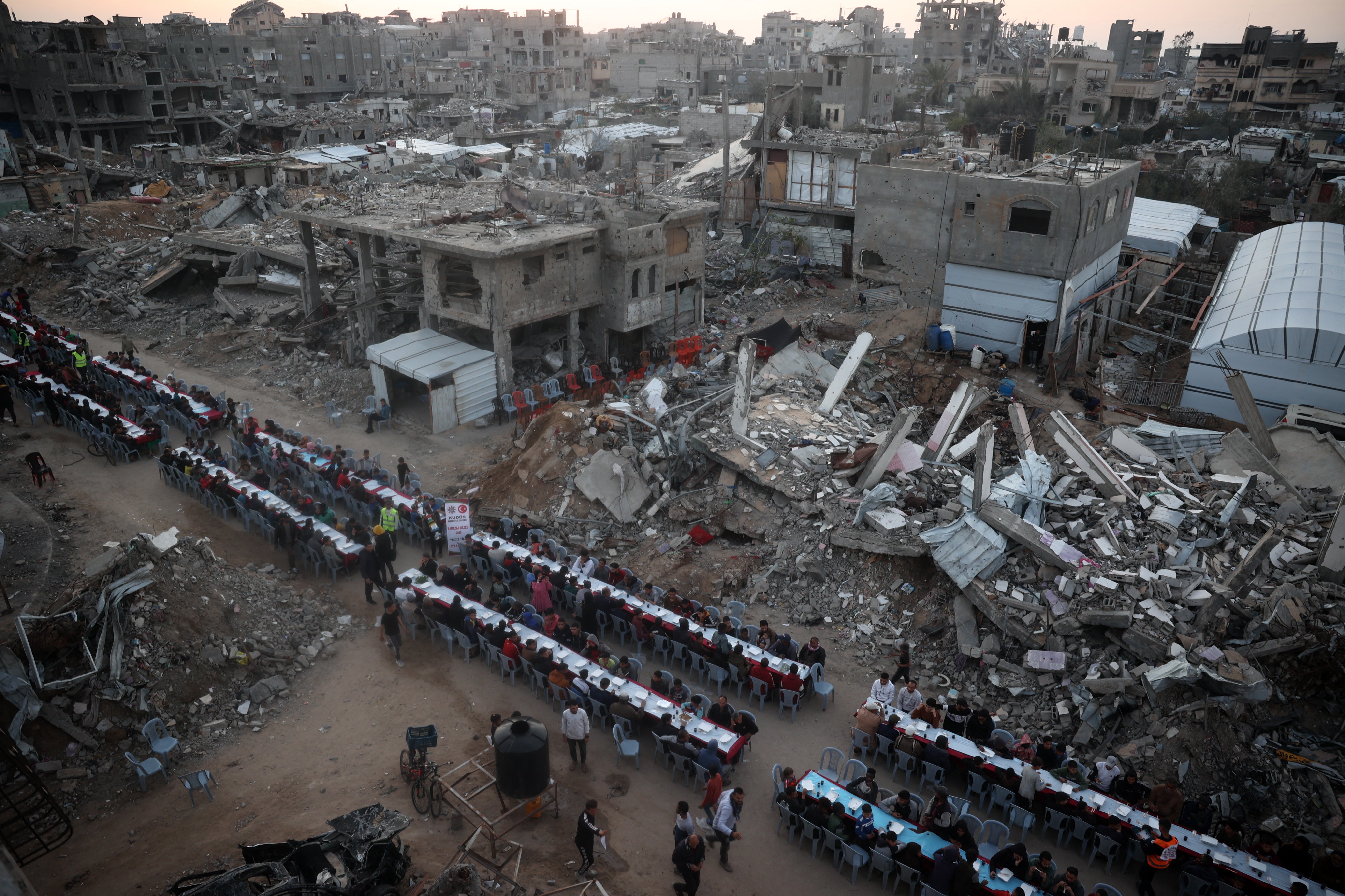 Palestinci se okupljaju za komunalni obrok iftara kako bi se brzo razbili usred pustošenja u izbjegličkom kampu Nuseirat u centralnoj traci Gaze u petak