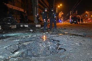 Policijski službenici stoje u blizini kratera nakon eksplozije
