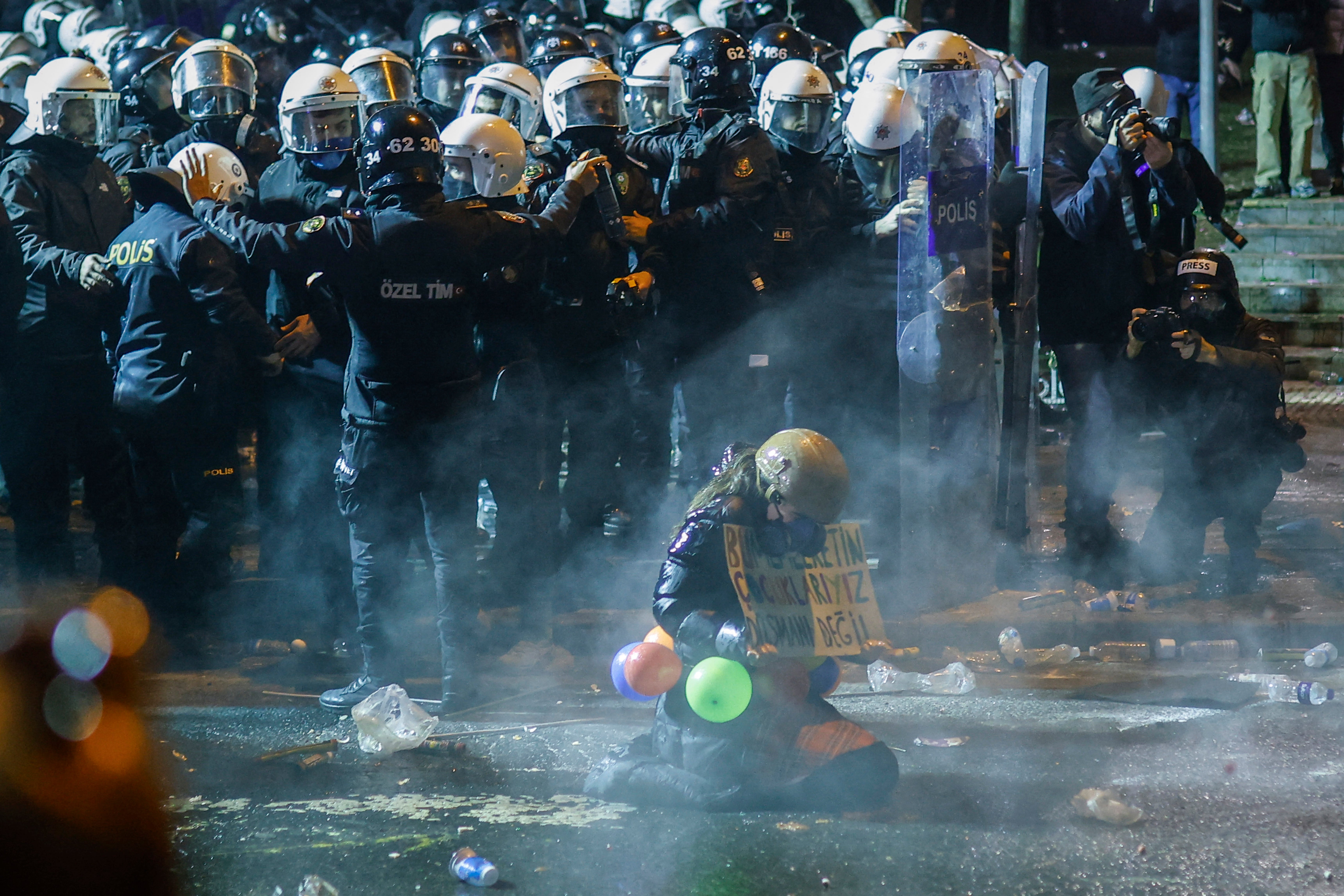 Prosvjednik drži plakatu usred suzalnog plina pored turske pobune tijekom demonstracije izvan gradske vijećnice Istanbula