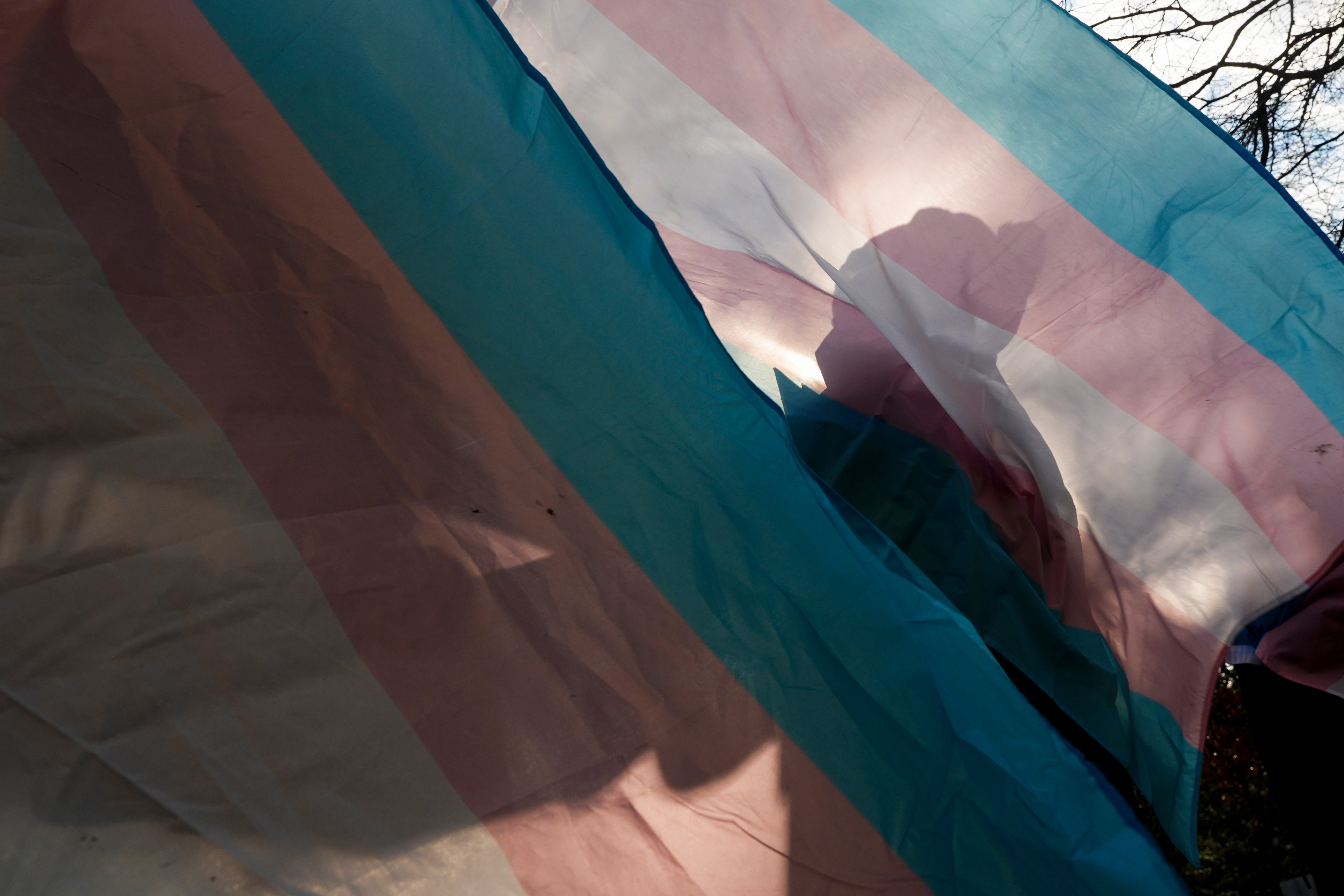 Prosvjednik se siluetira protiv zastave Trans Pride tijekom prosvjeda za pro-transgender, izvan dječje bolnice u Seattlu, 9. veljače 2025. u Seattlu. (AP Photo/Lindsey Wasson, datoteka)