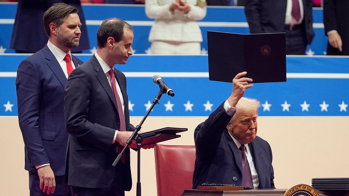 Predsjednik Donald Trump potpisuje izvršne naredbe na pozornici