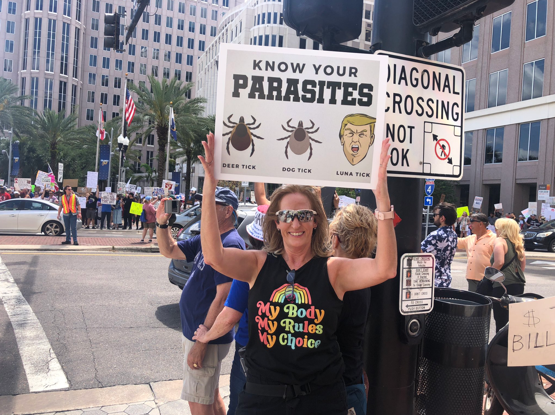 Žena na Floridi s ponosom drži znak koji osuđuje na djela Trumpove administracije