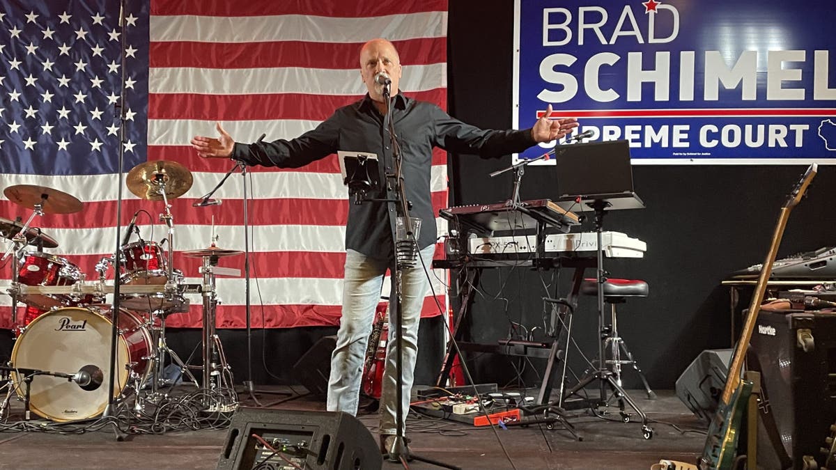 Brad Schimel na pozornici, američka zastava iza njega