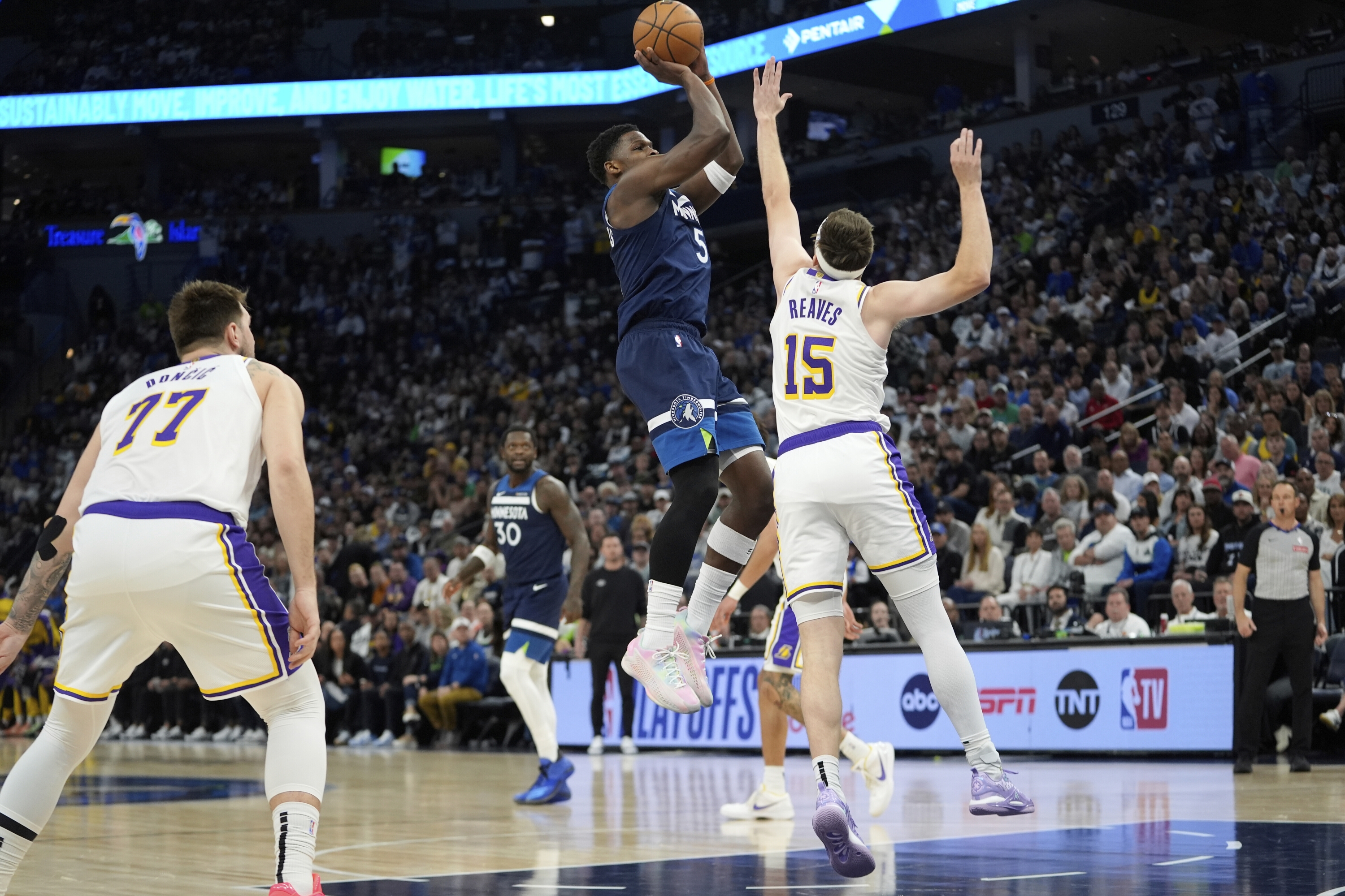 Čuvar Minnesota Timberwolves Anthony Edwards (5) puca preko Los Angeles Lakersa čuvara Austina Reavesa (15) tijekom prve polovice utakmice 4 NBA košarkaške serije prvog košarke, u nedjelju, 27. travnja 2025., u Minneapolisu. (AP Photo/Abbie Parr)
