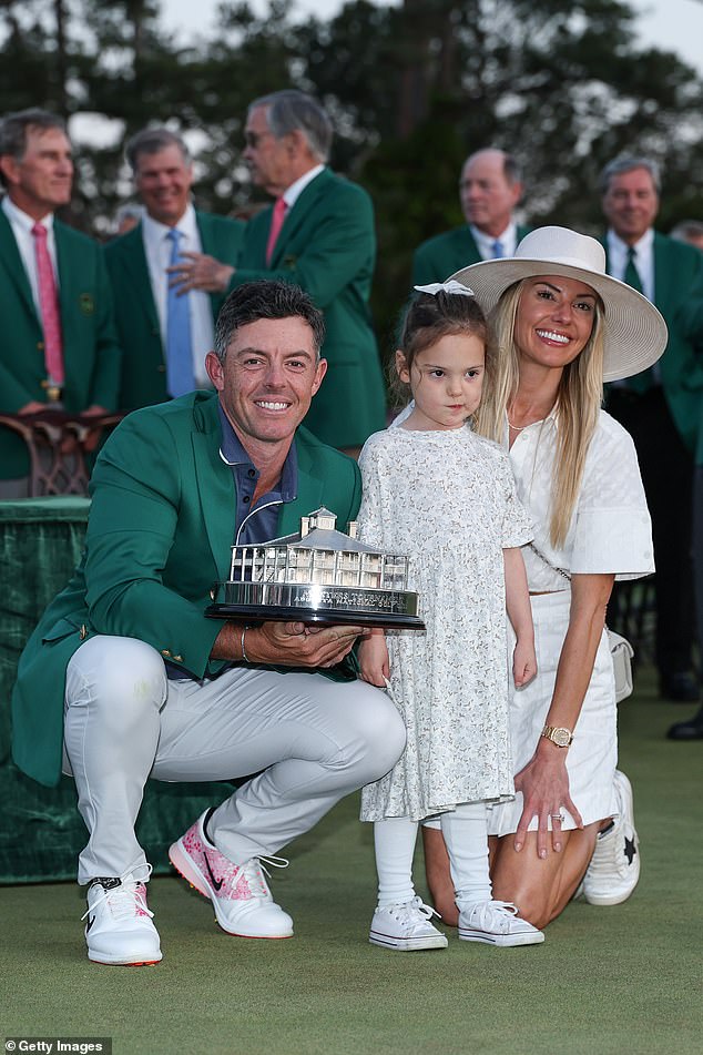 Četverogodišnjak pozira zajedno sa svojim trijumfalnim ocem, koji stisne trofej Masters