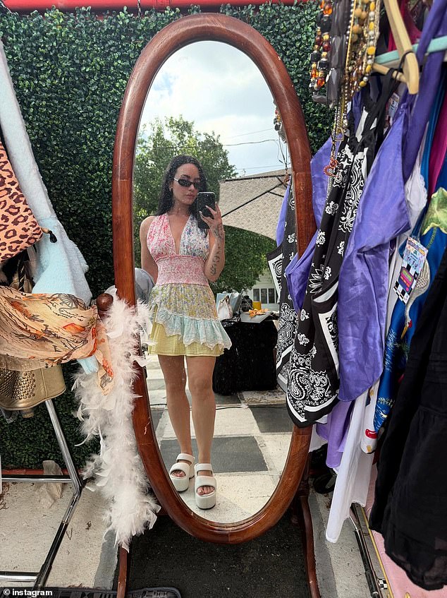 Navela je šarenu haljinu i bijele sandale platforme dok je provjeravala svoj odraz na stajalištu odjeće