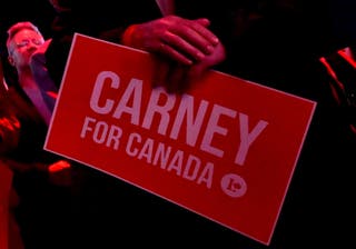 Zagovornik kanadskog premijera Marka Carneyja ima znak u sjedištu Liberalne zabave u Ontawi, Ontario, Kanada, 28. travnja 2025.