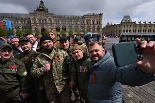 Čovjek slika selfie s ruskim vojnicima uključenim u vojnu akciju zemlje u Ukrajini nakon vojne parade Dana pobjede u središnjoj Moskvi