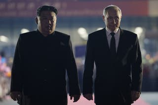 Ruski predsjednik Vladimir Putin (R) i sjevernokorejski vođa Kim Jong Un hodaju tijekom oproštaja nakon Putinovog odlaska na međunarodnu zračnu luku Sunan u Pjongjangu