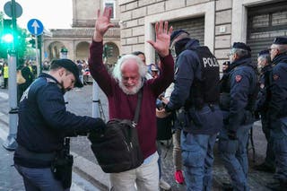 Stariji muškarac podiže ruke dok policajac provjerava svoju torbu na policijskoj sigurnosnoj provjeri na ulici ispred pogreba pokojnog pape Franjo u blizini Vatikana, u Rimu
