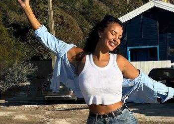 Maya Jama preplavljuje svoj napet midriff u bijelom kulturu i trapericama tijekom praznika dok dijeli priču o pubu u New Yorku