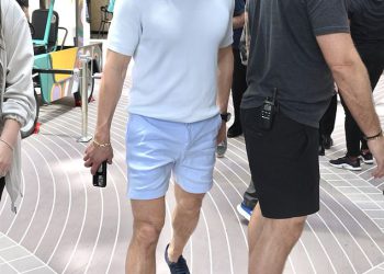Orlando Bloom reže hladnu figuru u plavim kratkim hlačama i polo majici dok prisustvuje događaju pokretanja krstarenja s Drewom Barrymoreom