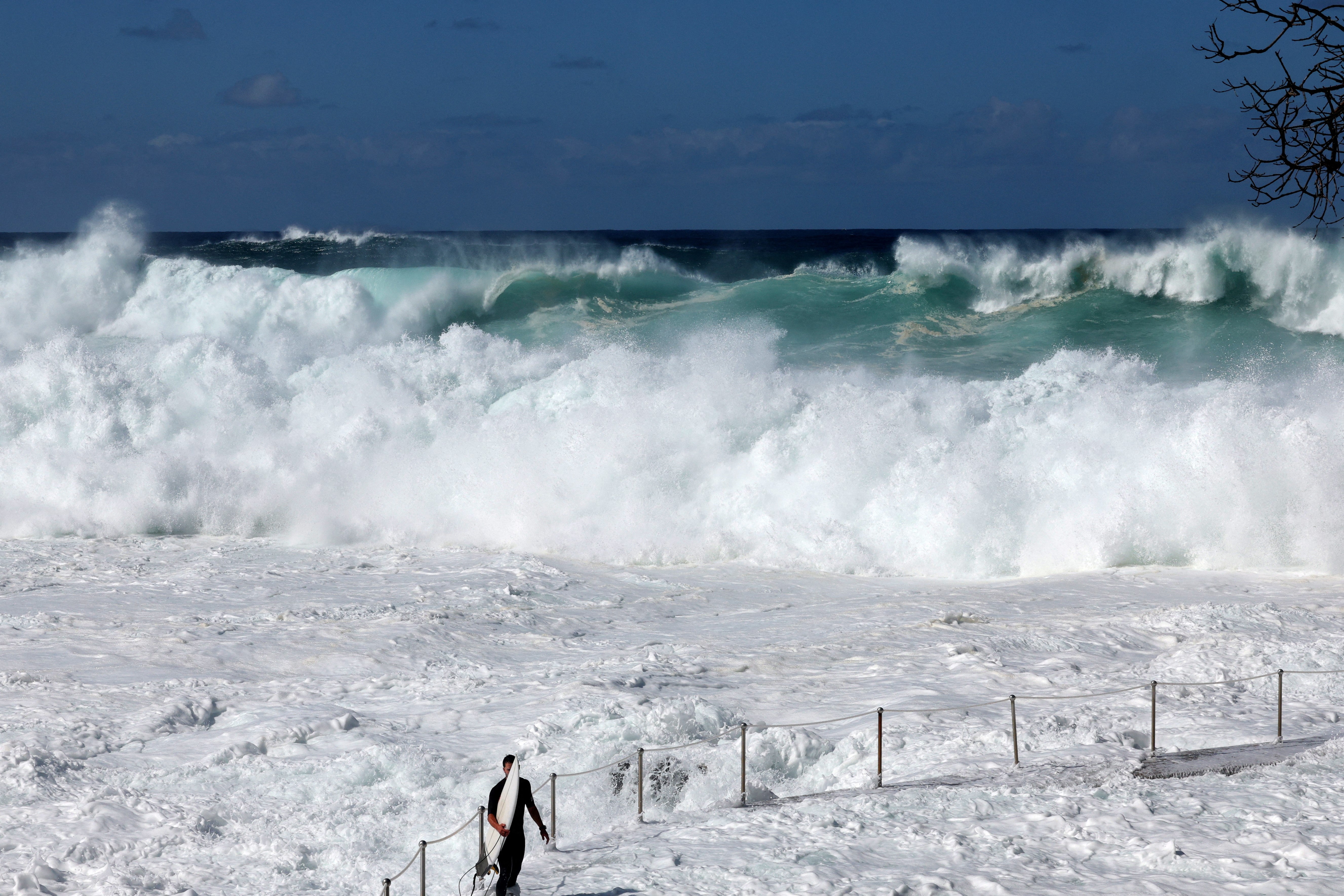 Surfer čeka veliki val na plaži Bronte u Sydneyu, 18. travnja 2025. godine, usred snažnih nabuljeća udarajući u Istočnu obalu Australije