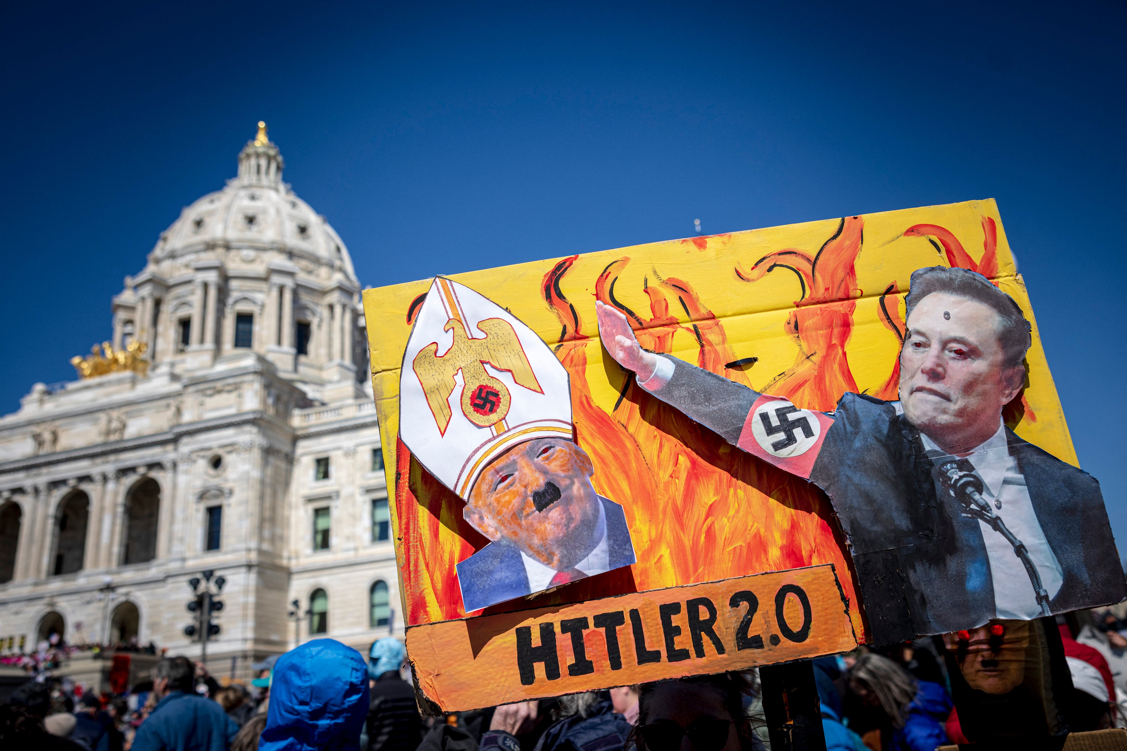 Prosvjednici u St. Paulu, Minnesota, održali su znak uspoređujući Trumpa i mošusa s nacistima, uključujući fotografiju najbogatije osobe na svijetu koja radi 'nacistički pozdrav' na događaju inauguracije u siječnju