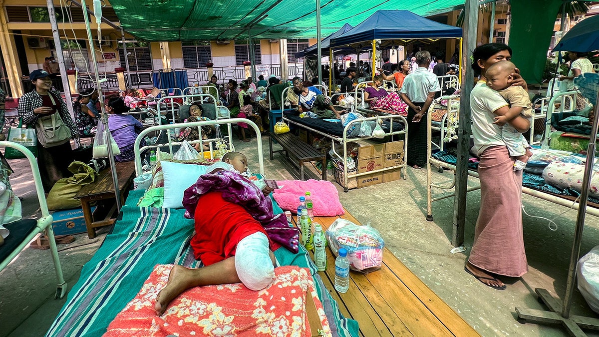 Ljudi leže na krevetima u blizini bolnice Burme