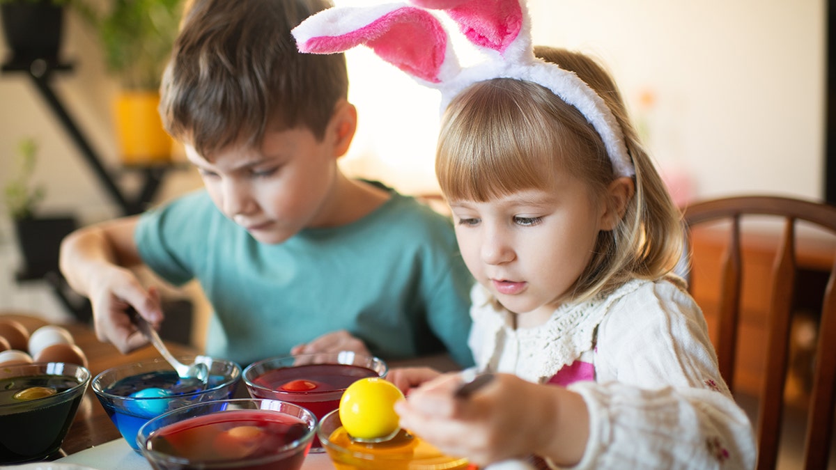 djeca bojanje uskršnjih jaja stock photo