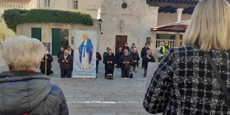 ‘Javna površina nije vaš oltar’, ‘Kleči doma, trg je za život’, ‘Kleči doma, ne po mojim pravima!’: Ovo su poruke s trogirskog trga za vrijeme molitve muškaraca
