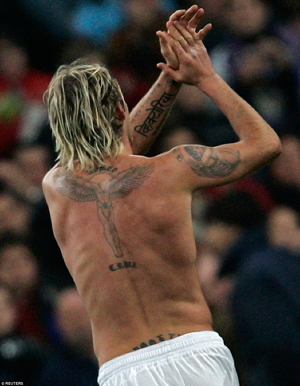 Beckham's next tattoo, a large guardian angel between his shoulder blades, is prominent among his array of designs