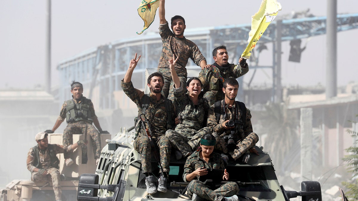 Borice sirijskih demokratskih snaga (SDF) voze se na vrhu vojnih vozila dok slave pobjedu u Raqqa, Sirija, 17. listopada 2017. Reuters/Erik de Castro TPX slike dana - RC18150D4560