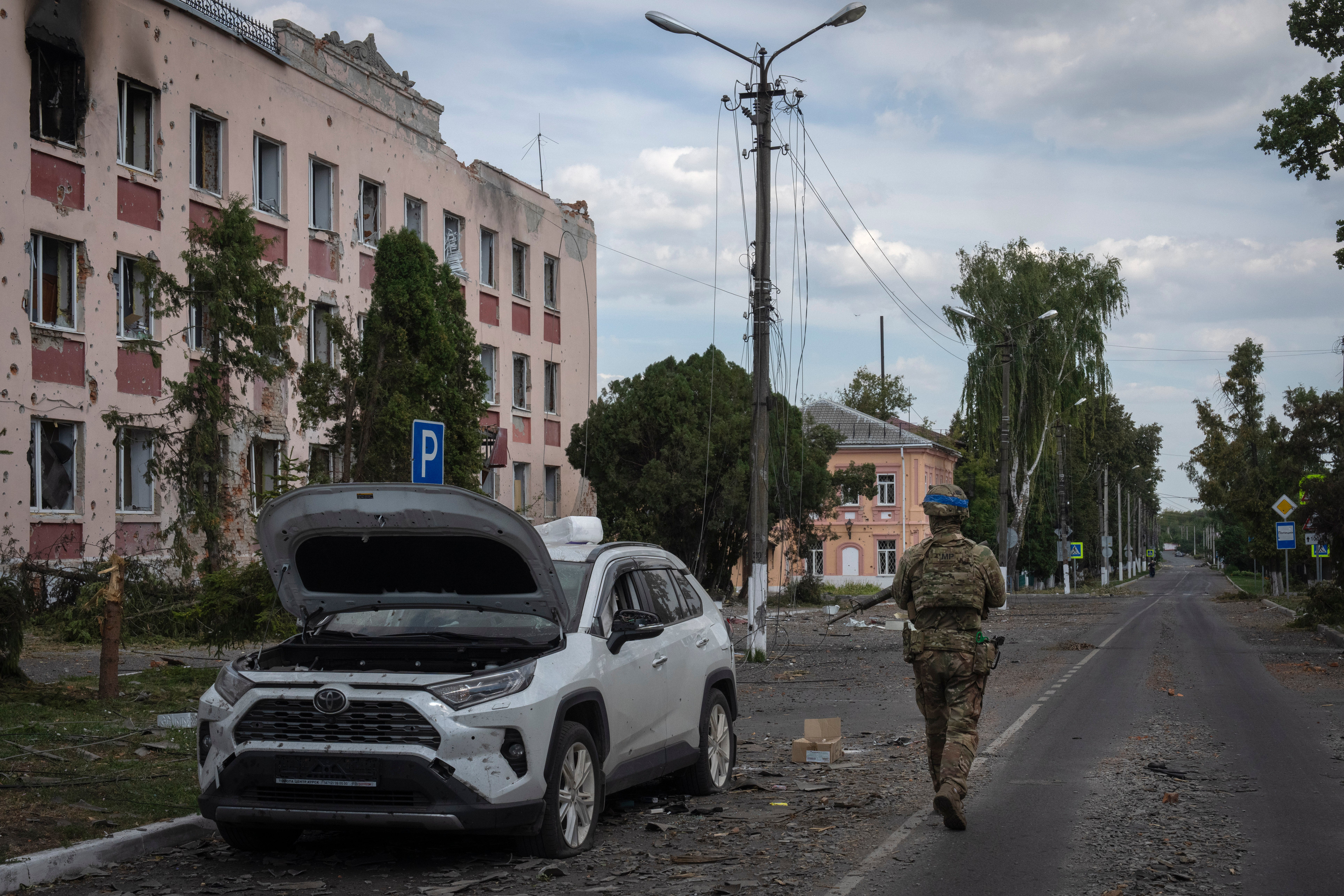 A Ukrainian soldier walks past a building in the Kursk region of Russia, in August 2024