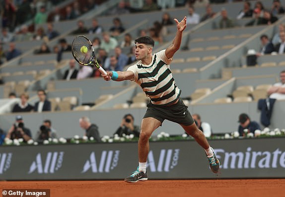 PARIS, FRANCE - MAY 28: Carlos Alcaraz of Spain plays a backhand against Fabian Marozsan of Hungary during the Men's Singles Second Round match on Day Four of the 2025 French Open at Roland Garros on May 28, 2025 in Paris, France. (Photo by Adam Pretty/Getty Images)