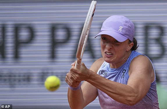 Poland's Iga Swiatek returns the ball to Britain's Emma Raducanu during their second round match of the French Tennis Open, at the Roland-Garros stadium, in Paris, Wednesday, May 28, 2025. (AP Photo/Christophe Ena)