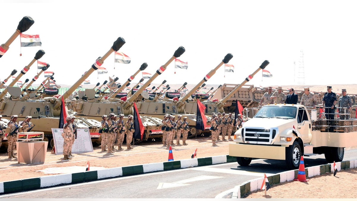 Egipatski predsjednik Abdel Fattah al-Sisi stoji na pokretnom inspekcijskom vozilu zajedno s vojnim časnicima, jer su redovi egipatskih vojnika i samohodne artiljerijske jedinice prikazani u Suezu.