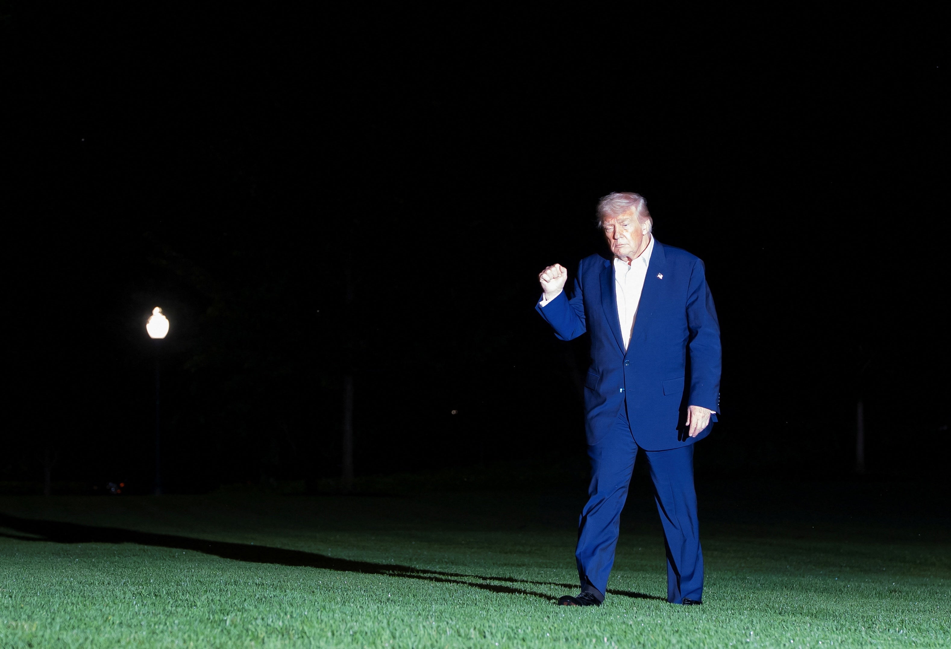 Predsjednik Donald Trump gestikulira dok hoda po južnom travnjaku dok se vraća u Bijelu kuću nakon putovanja na Bliski Istok u petak