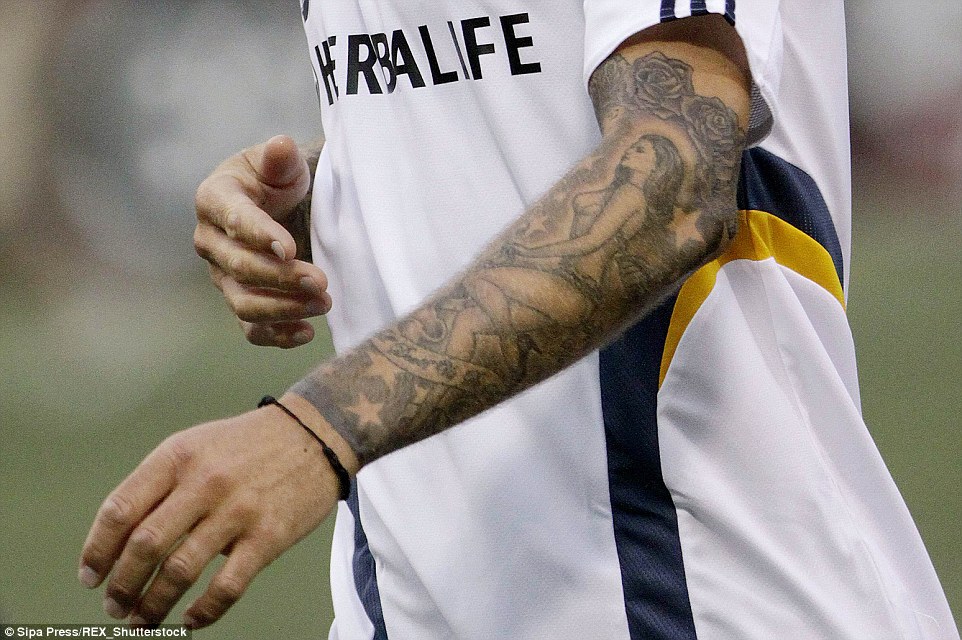 A female figure covers the length of Beckham's upper left forearm