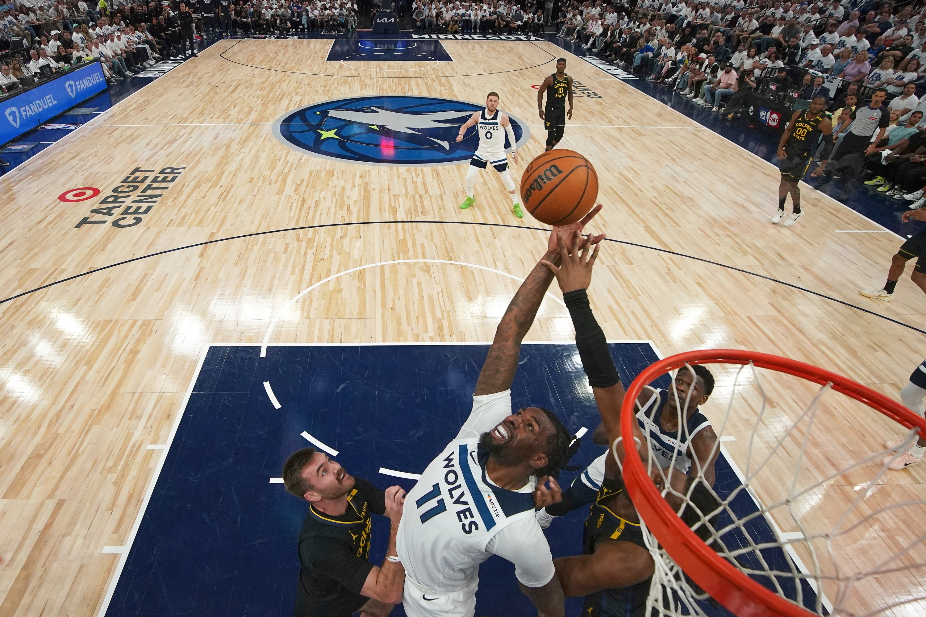 Minnesota Timberwolves Center Naz Reid (11) posegne za skokom protiv čuvara Golden State Warriorsa Pat Spencera, lijevo, i napadača Kevona Looneyja, desno, tijekom drugog poluvremena igre 1 NBA košarkaške serije u drugom krugu doigravanja, u utorak, 6. svibnja 2025., u Minneapolisu. (AP Photo/Abbie Parr)
