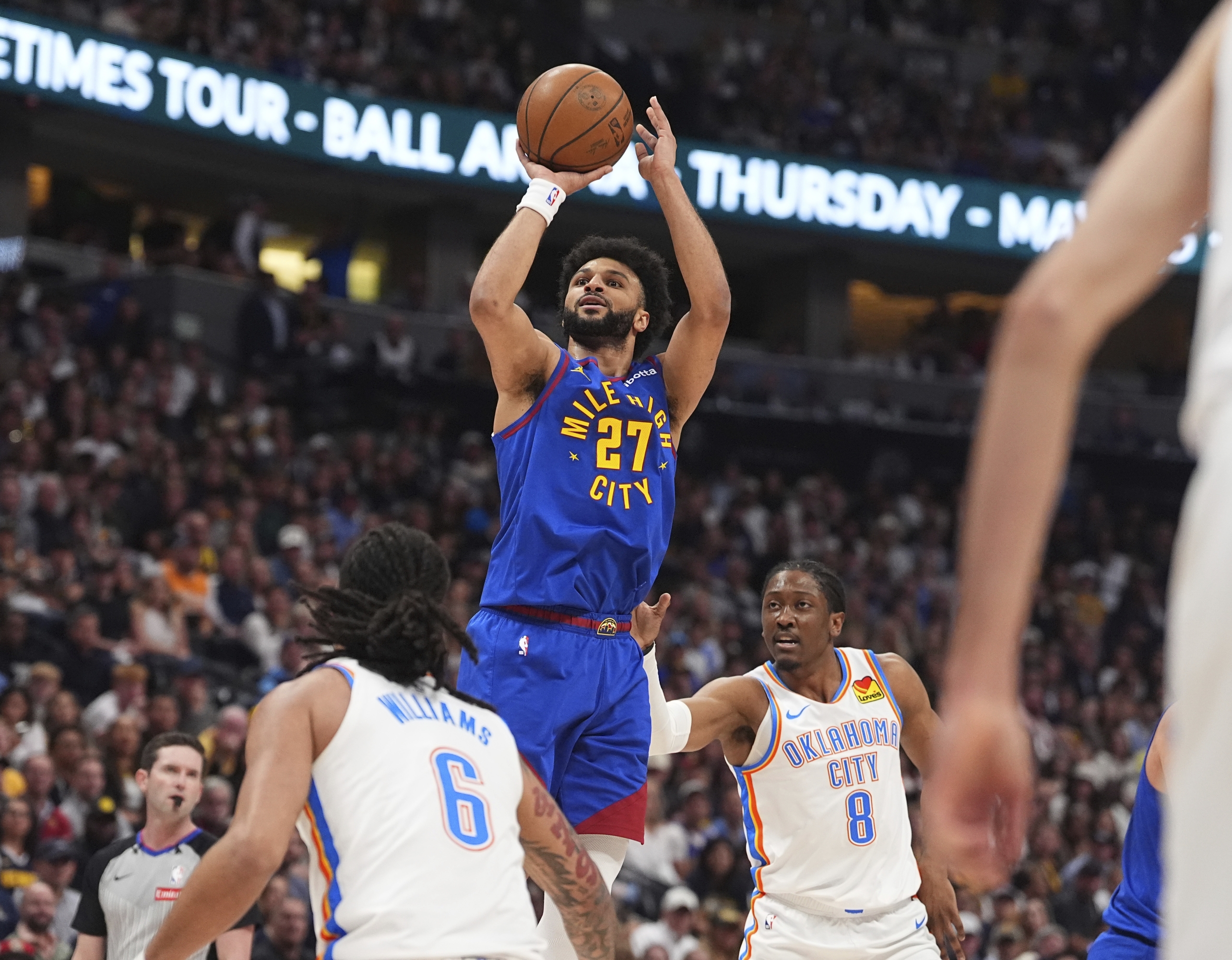 Denver Nuggets čuvar Jamal Murray (27) ide u košaru između napadača Oklahoma Cityja, Jaylin Williams (6) i Jalen Williams (8) u prvom poluvremenu 3 u polufinalu Western Conference polufinala NBA košarkaške doigravanja u petak, 9. svibnja, 2025., u Denveru. (AP Photo/David Zalubowski)
