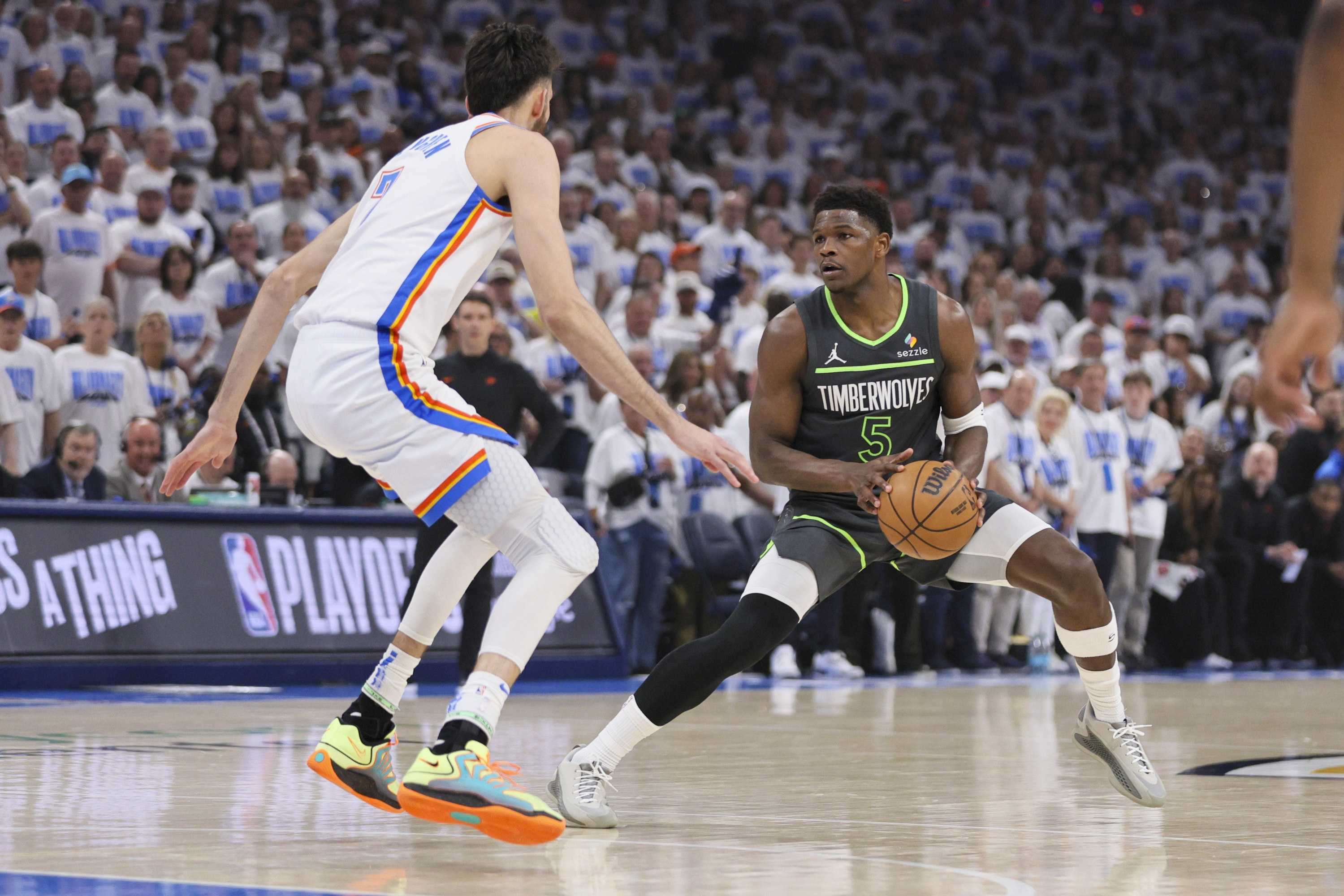 Minnesota Timberwolves čuvar Anthonyja Edwardsa (5) radi na katu protiv Oklahoma City Thunder naprijed Chet Holmgren tijekom prve polovice utakmice 1 od NBA košarkaške finalne serije Western Conference u utorak, 20. svibnja 2025., u Oklahoma Cityju. (AP Photo/Nate Billings)