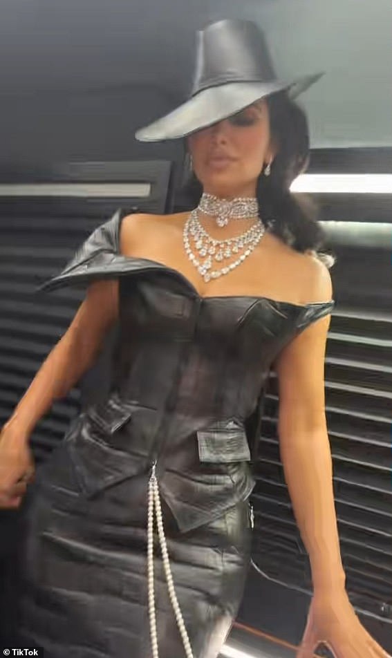 Kim je odlučila donijeti malo kože u dugoj haljini Bodycon -a s odgovarajućim velikim Fedorom po kromiranim srcima