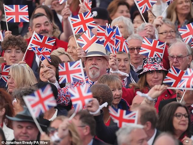 Članovi publike zamislili su kako mašu svoje zastavama sindikata tijekom koncerta slaveći 80. obljetnicu VE Dana