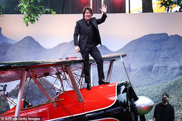 Ne propuštajući priliku za štos, Tom se pobrinuo da se popne na crveni avion na crveni tepih kako bi mahnuo navijačima odozgo