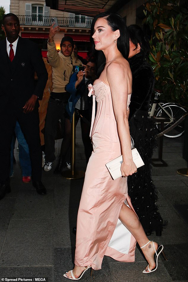 Katy je izrezala glamuroznu figuru u prašnjavoj ružičastoj svilenoj haljini od korzeta s visokim prorezom na stražnjoj strani