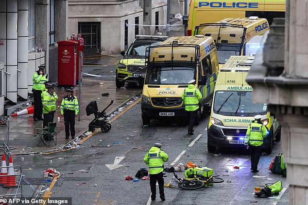 Police officers investigate the scene of an incident in Water Street, on the sidelines of an open-top bus victory parade for Liverpool's Premier League title win