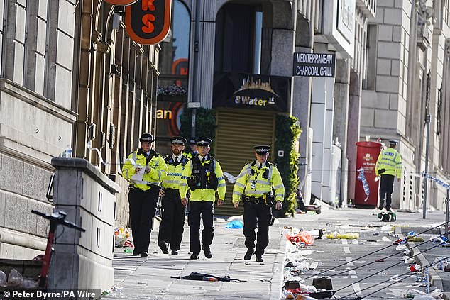 Police officers walk along Water Street near the Liver Building in Liverpool city centre this morning