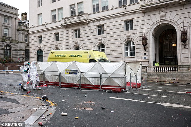 Two forensic detectives are seen investigating the scene near to where a car ploughed into the crowd