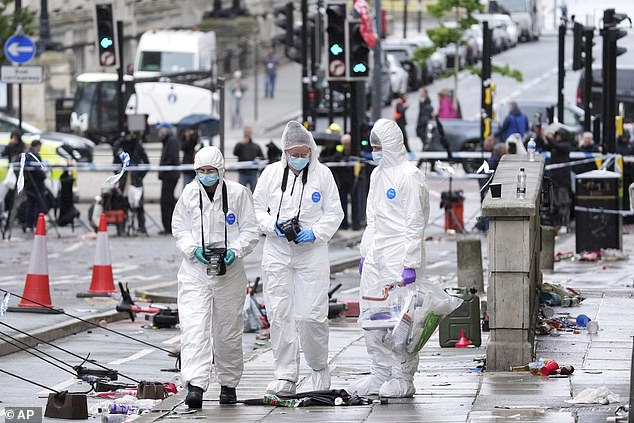 Police in forensic white suits were seen taking photographs of the area and collecting items