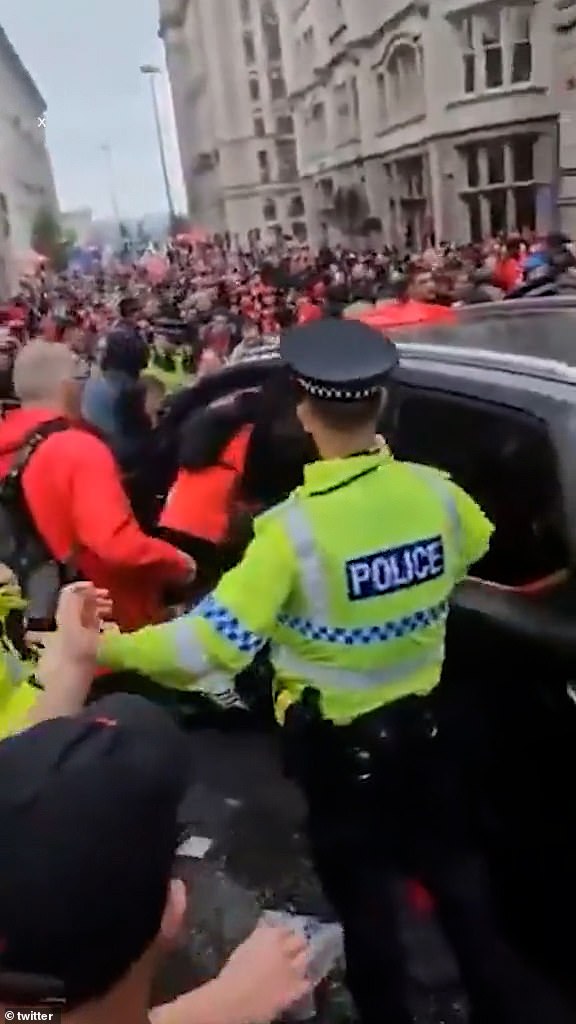 The crowd scramble to bring the car to a stop as bystanders lean into the vehicle