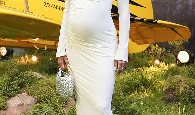 Arabella Chi pokazuje svoju rastuću bebu u kreme u elegantnoj vrhnjoj midi haljini dok pohađa londonsku premijeru misije: nemoguće 8 uoči svog neposrednog roka