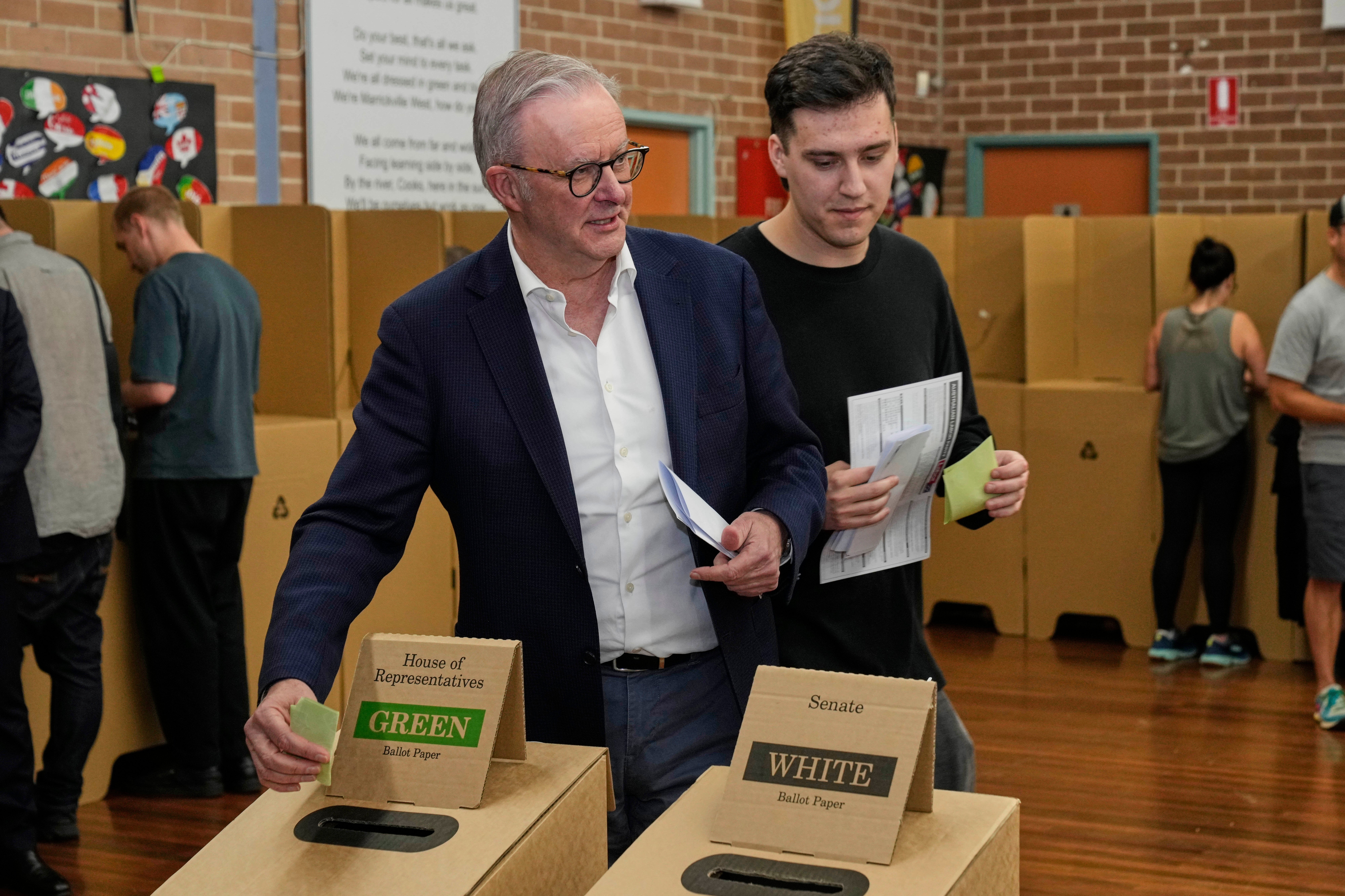 Australski premijer Anthony Albanese i njegov sin Nathan postavljaju svoje glasove u glasačku kutiju na biračkom kabinu u svom biračkom tijelu u Sydneyu, u subotu, 3. svibnja 2025.